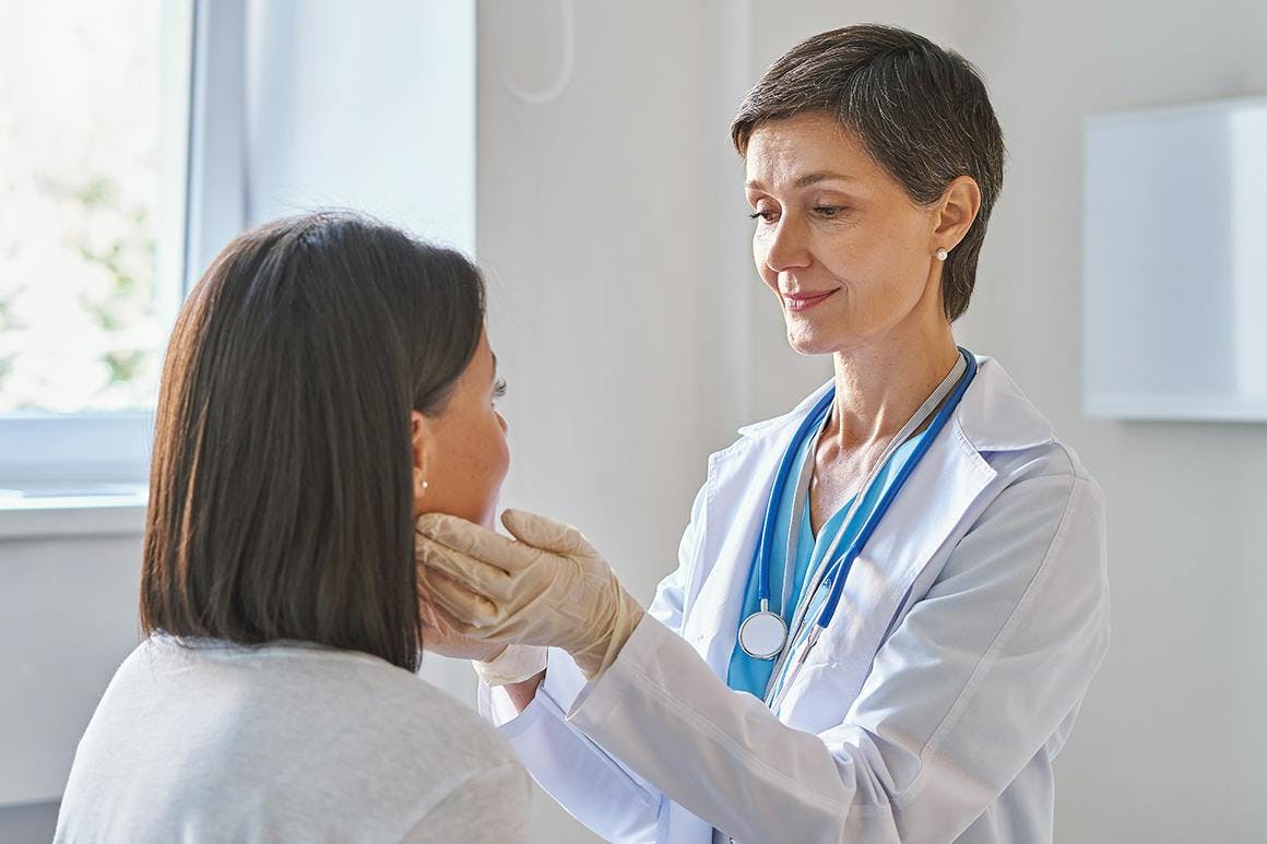 Physician checking patient neck